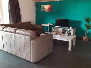 uma sala de estar com um sofá e uma mesa com uma televisão em 't Brugske em Deurne