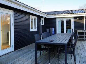 een zwarte tafel en stoelen op een houten terras bij Holiday home Jægerspris XXXVII in Jægerspris