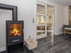 a fireplace in a living room with a fire in it at 8 person holiday home in Ringk bing in Ringkøbing