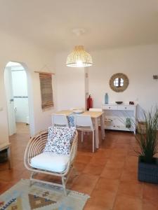 a living room with a table and a chair at Apartamento Riomar in Vila Nova de Milfontes
