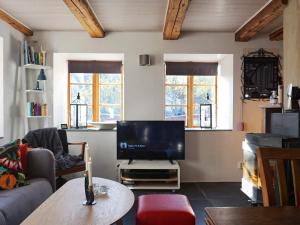 a living room with a couch and a tv at 4 person holiday home in SLITE in Slite