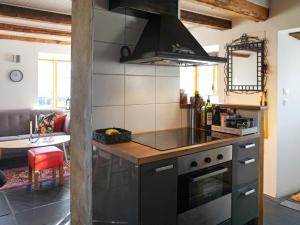 a kitchen with a stove top oven next to a living room at 4 person holiday home in SLITE in Slite