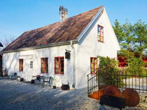 a white house with red windows and a fence at 4 person holiday home in SLITE in Slite