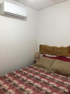 - une chambre avec un lit et une tête de lit en bois dans l'établissement Flat Eco Resort Praia Dos Carneiros PE, à Tamandaré