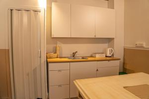 a kitchen with white cabinets and a sink at Bruno's Historic Home in Naples