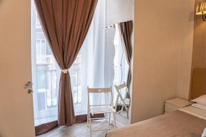 ナポリにあるブルーノズ ヒストリック ホームのベッド1台、窓(椅子付)が備わる客室です。