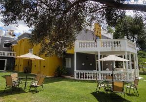 une table et des chaises devant une maison jaune dans l'établissement Hotel San Marcos, à San Marcos Sierras