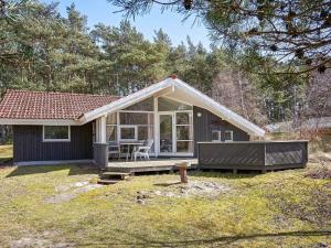 uma pequena casa com um alpendre e um pátio em Holiday home Aakirkeby XIV em Vester Sømarken