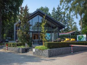 a house with a black roof on a street at Nice chalet with garden at the Utrechtse Heuvelrug in Rhenen