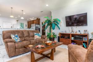 a living room with a couch and a table at West Beach - Stay ON the sand! Gulf views galore, only steps to the shore! home in Dauphin Island
