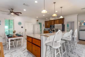 a kitchen with white appliances and white stools at West Beach - Stay ON the sand! Gulf views galore, only steps to the shore! home in Dauphin Island