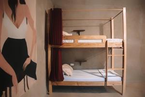 a room with two bunk beds with a mirror at Fable Hostel in Siquijor