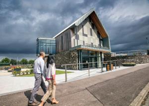 a man and woman walking in front of a building at An Lar in Bellaghy