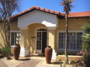 a house with a palm tree in front of it at Auberge Guest Lodge in Nelspruit