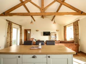 a kitchen with a table and a living room at Sunnyside Cottage in Middleton