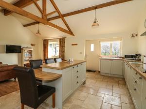 a kitchen with a table and chairs in a room at Sunnyside Cottage in Middleton