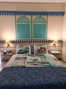 - une chambre avec un grand lit et une couette bleue dans l'établissement Studio dans Résidence Hotelière aux 3ilets Pointe du bout Résidence la Marina Carayou, à Les Trois-Îlets