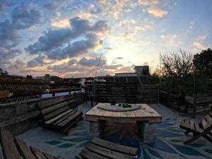 un patio con panchine e fontana con cielo nuvoloso di Hostal Posada Mi Casa a San Cristóbal de Las Casas