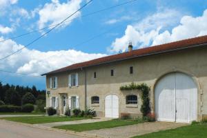 un grand bâtiment avec un garage dans une rue dans l'établissement Lorraine country house near Lake Madine, Lahayville, à Lahayville