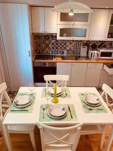cocina con mesa blanca y sillas blancas en IGI WHITE FLAT with free private parking en Cluj-Napoca