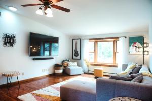 a living room with a couch and a tv at Sylvan Rhapsody- Stowe Village classic in Stowe