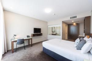a hotel room with a bed and a television at Sfera's Park Suites & Convention Centre in Adelaide