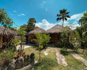 una casa con una palma di fronte di Herbs Guest House and Restaurant near the Sea a Moalboal