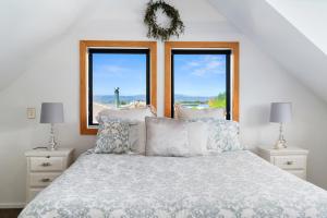 a bedroom with a bed with two windows at The Maples - Clyde Holiday Home in Clyde