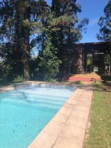 a swimming pool in front of a house at El bosque serrano in Sierra de los Padres