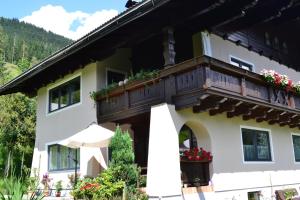 a building with a balcony with flowers on it at Ferienapartment Frahndl in Eben im Pongau
