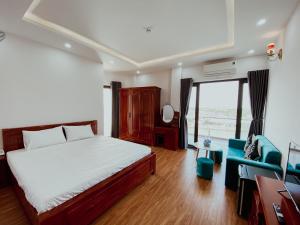 a bedroom with a bed and a couch and a window at Khách sạn Ngọc Hồi in Quy Nhon