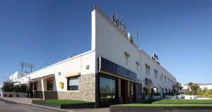 a white building on a street at Hotel Venta del Pobre in Níjar