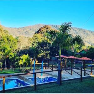圣代佩德罗Cabana Hostel Sobrado EcoPark的棕榈树和游泳池的度假村
