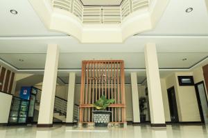 a lobby with a chair and a plant in it at Crystal City Hotel in Mataram