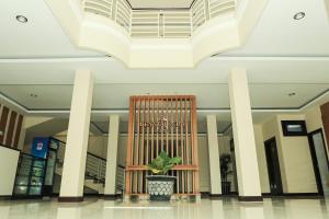um lobby com uma cadeira e uma planta nele em Crystal City Hotel em Mataram