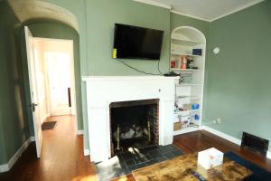 a living room with a fireplace with a tv above it at Blue House, Blocks from Ross-Aide, Mackey, Samara House, Birck Golf Complex in West Lafayette
