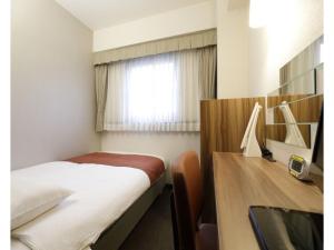 Schlafzimmer mit einem Bett, einem Schreibtisch und einem Fenster in der Unterkunft Tokyo Inn - Vacation STAY 10241v in Tokio