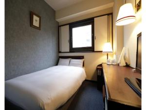 um quarto de hotel com uma cama, uma secretária e uma janela em Tokyo Inn - Vacation STAY 11125v em Tóquio