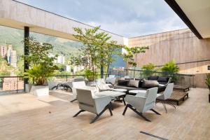 a patio with white chairs and tables on a building at Energy 801 in Medellín