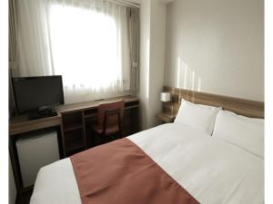 a bedroom with a bed and a desk and a television at Tokyo Inn - Vacation STAY 11124v in Tokyo