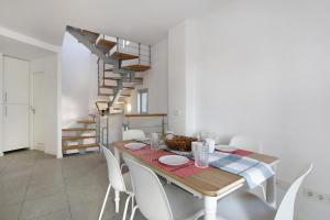 a dining room with a table and white chairs at Beautiful Duplex Facing The Beach in El Médano
