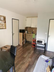 a living room with a table and a kitchen at Joli Appartement 2 pièces 4 voyageurs tout équipé 13 avenue de la Divette 14390 CABOURG in Cabourg