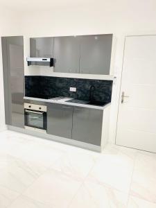 een witte keuken met een wastafel en een fornuis bij Villa cadette, à 200m de monaco in Beausoleil