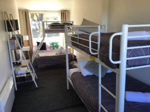 a dorm room with two bunk beds and a window at Boomers Retreat, Alonnah, Bruny Island in Alonnah