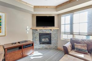 a living room with a fireplace and a flat screen tv at Modern Condo - Great Location! in Bear Valley +16 photos