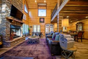 ein Wohnzimmer mit einem Sofa und einem Kamin in der Unterkunft The Nomi Lodge - Sleeps 28 - Gorgeous Rustic Cabin, Centrally Located, Tons of Amenities in Broken Bow