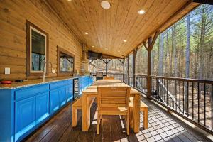 a kitchen with a table and chairs on a deck at The Nomi Lodge - Sleeps 28 - Gorgeous Rustic Cabin, Centrally Located, Tons of Amenities in Broken Bow