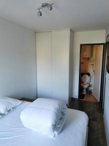 a bedroom with a white bed and a toilet at Joli Appartement 2 pièces 4 voyageurs tout équipé 13 avenue de la Divette 14390 CABOURG in Cabourg