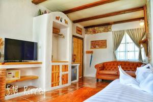 a living room with a couch and a television at Swiss Hotel Pattaya in Sattahip