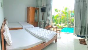 1 Schlafzimmer mit 2 Betten und einem großen Fenster in der Unterkunft Khách Sạn MiNi Phú Quý in Cu Lao Thu